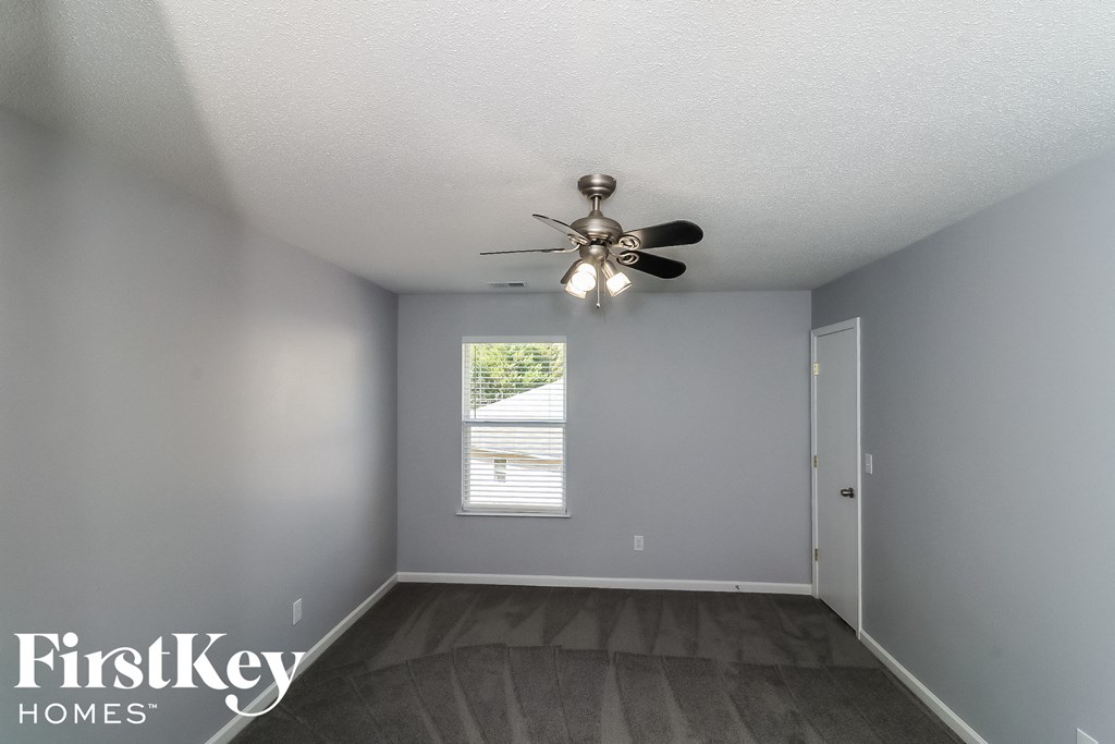 a bedroom with a ceiling fan and a window