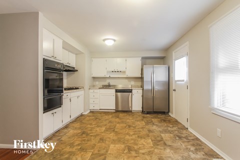 a renovated kitchen with white cabinets and stainless steel appliances