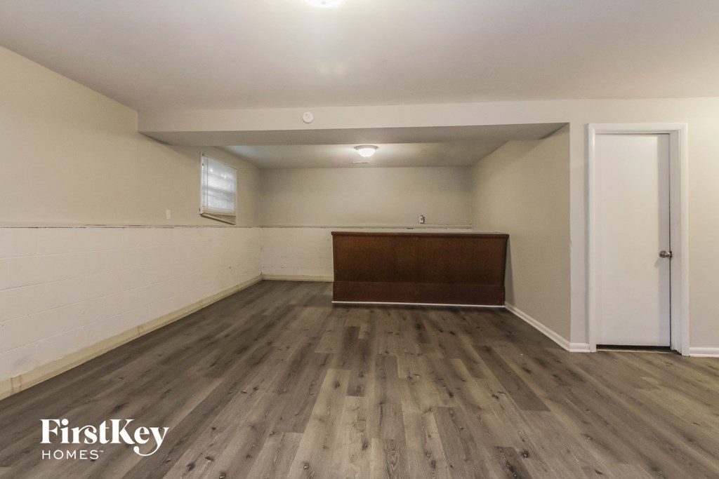 the living room of a house with wooden floors and white walls
