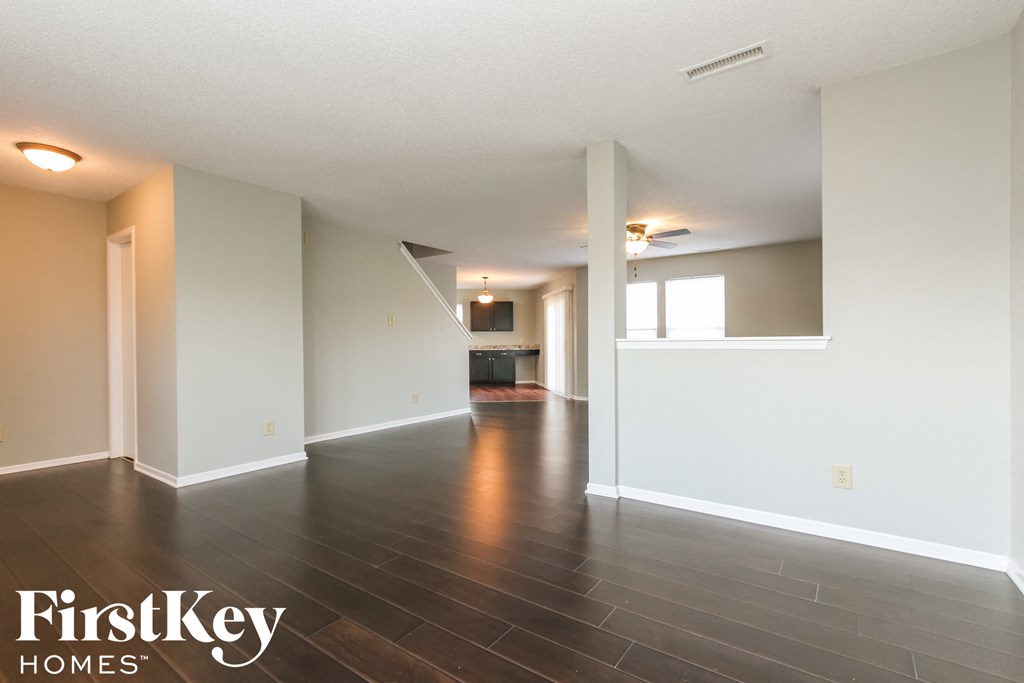 an empty living room with white walls and wood floors
