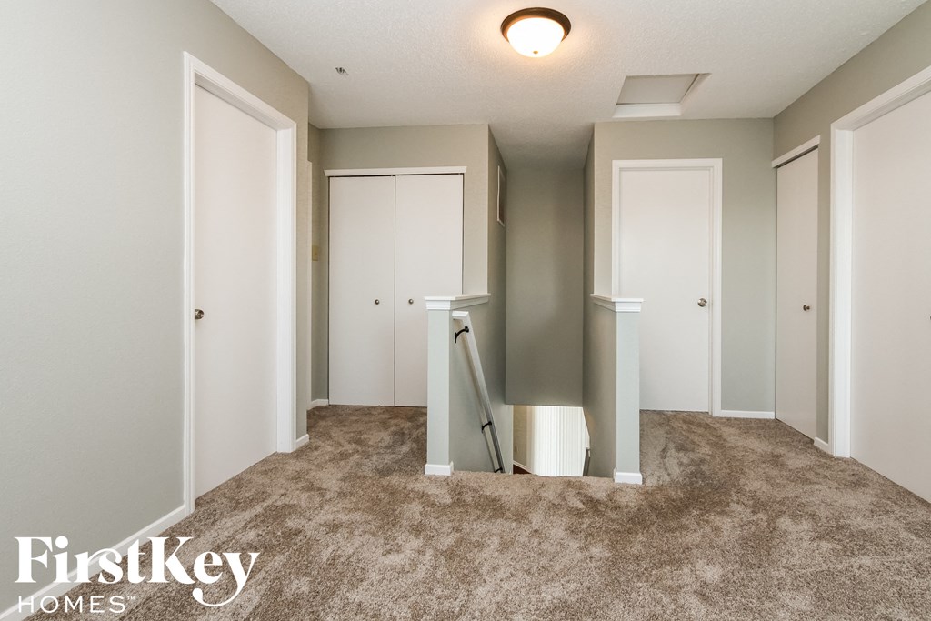 a walk in closet with mirrored doors and a carpeted floor