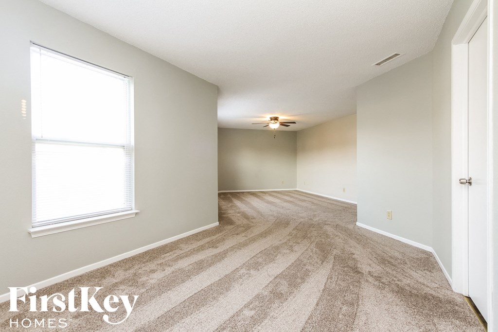 a spacious living room with carpet and a large window