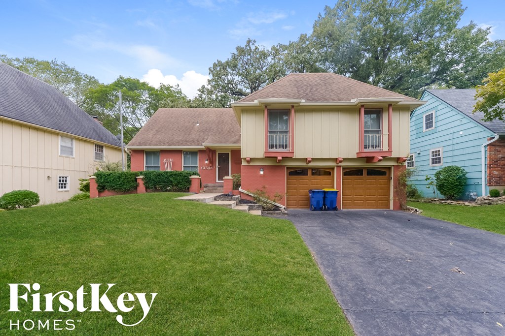 a home with a driveway and a lawn in front of it