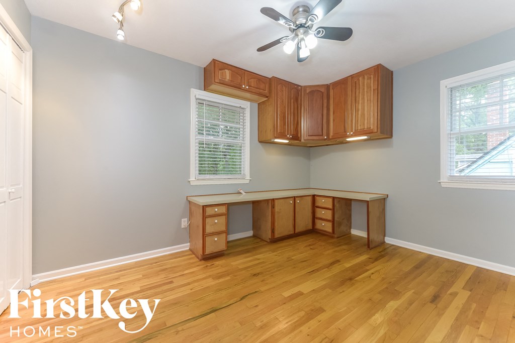 a home office with a desk and a ceiling fan