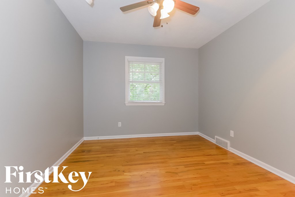 the second bedroom has a hardwood floor and a ceiling fan