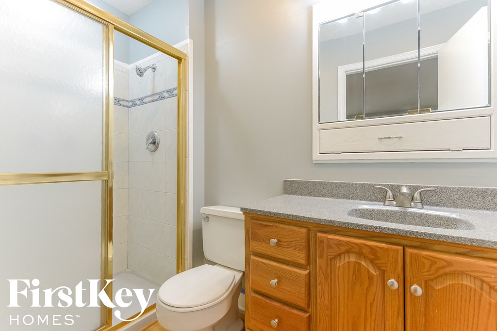 a bathroom with a toilet and a sink and a shower