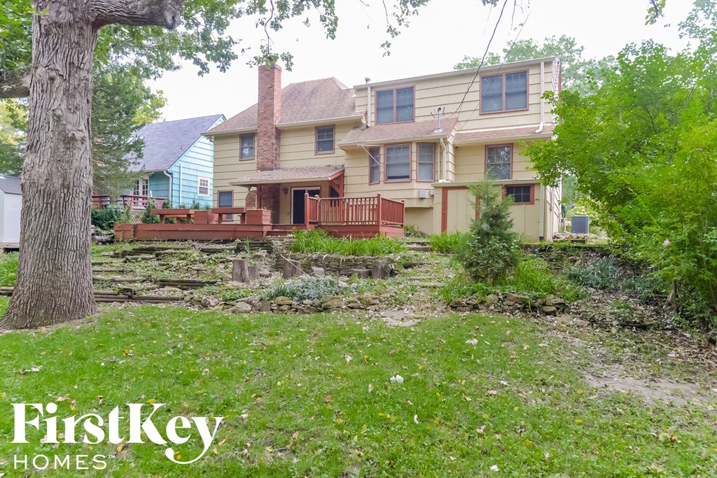 the backyard of a house with a wooden deck
