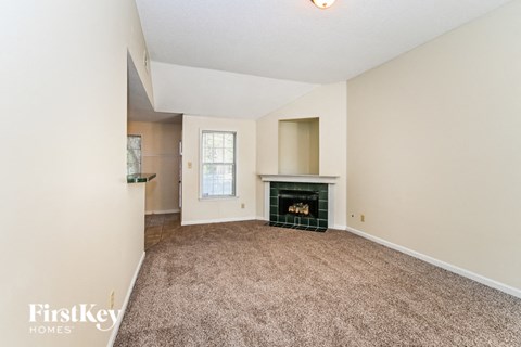 a living room with a fireplace and a carpeted floor