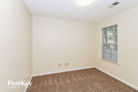 a spacious room with carpet and a window