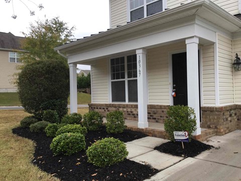 a front porch with a sign in front of a house