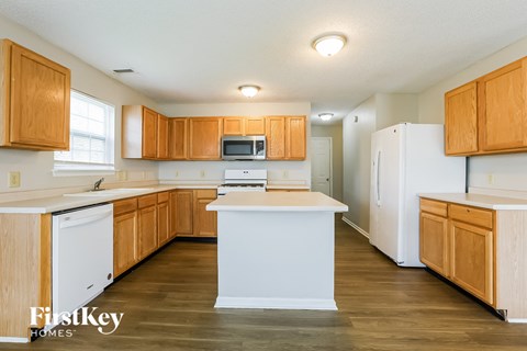 A kitchen with wooden cabinets and a white refrigerator.