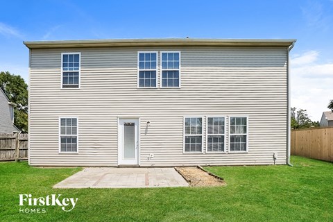A two-story house with a grey exterior and a white door.