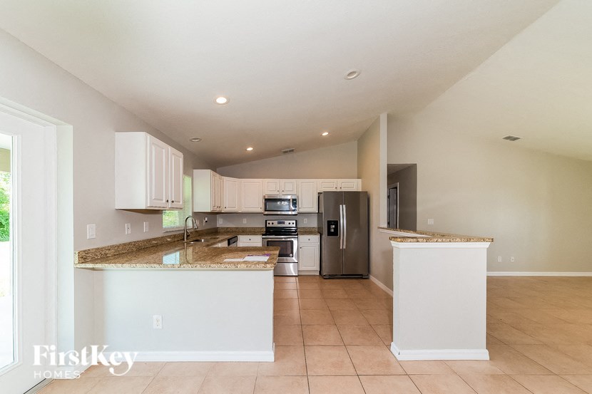 a kitchen with an island and a stainless steel refrigerator