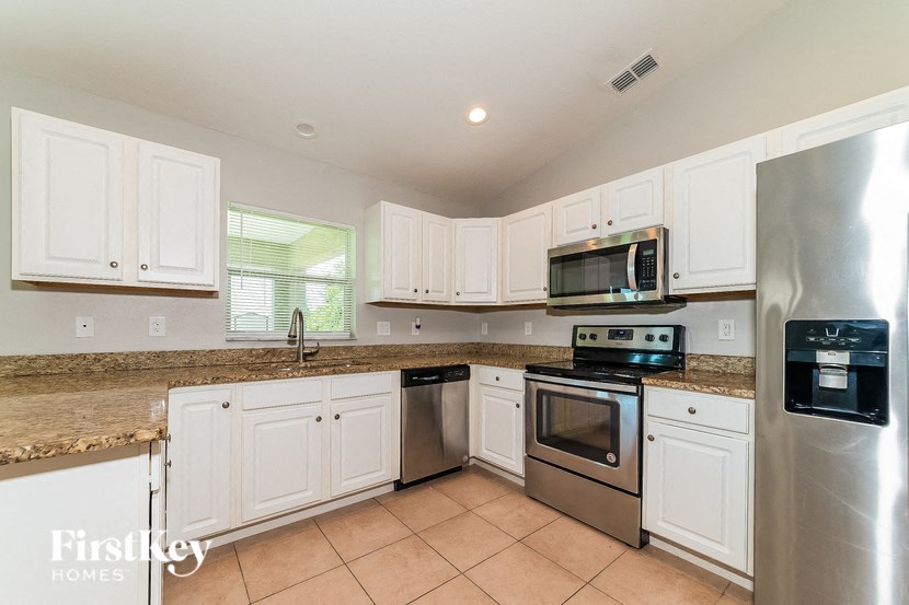 a kitchen with white cabinets and stainless steel appliances