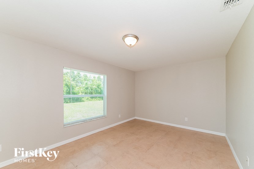 an empty room with a large window and tiled floors