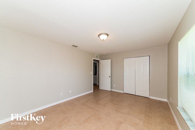 a large living room with a tile floor and a white door