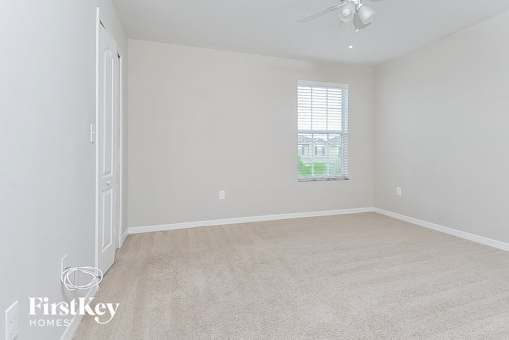 a bedroom with a carpeted floor and a window