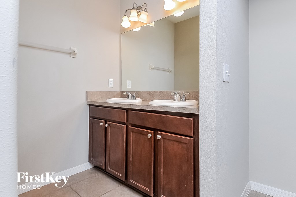 a bathroom with two sinks and a large mirror