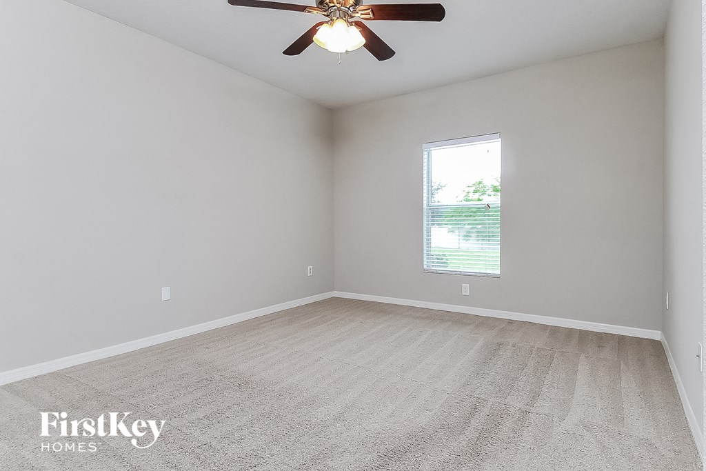the living room of an empty home with a ceiling fan