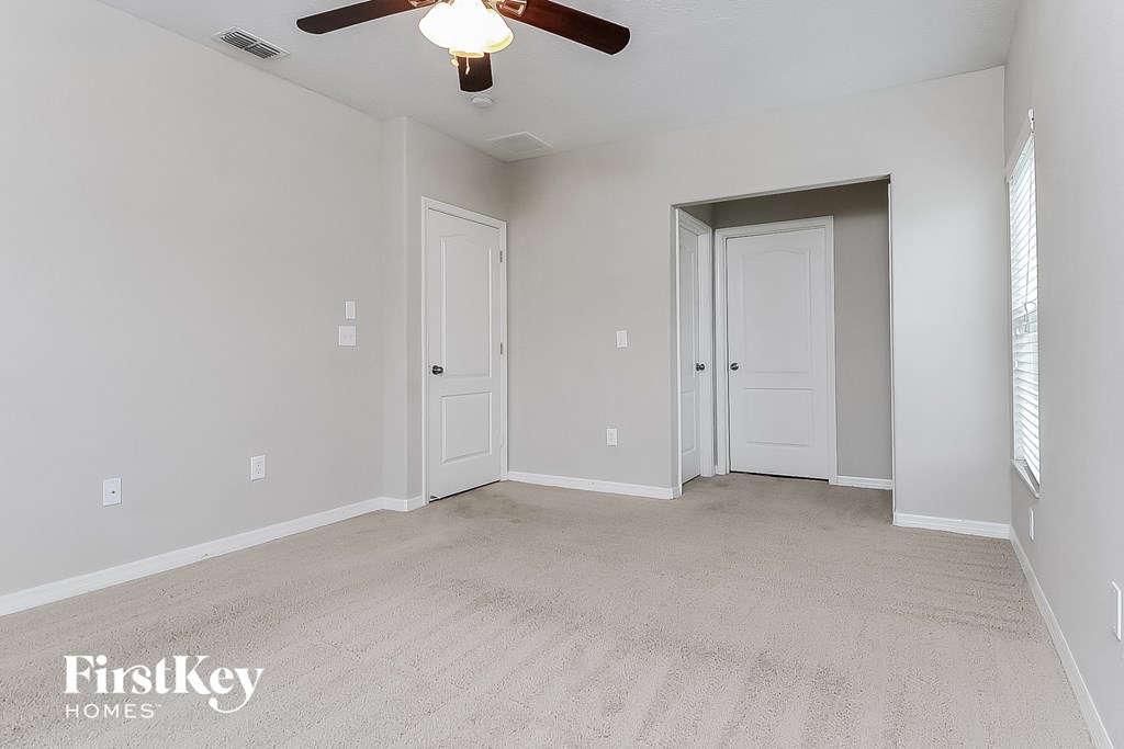 the living room of an empty house with a ceiling fan
