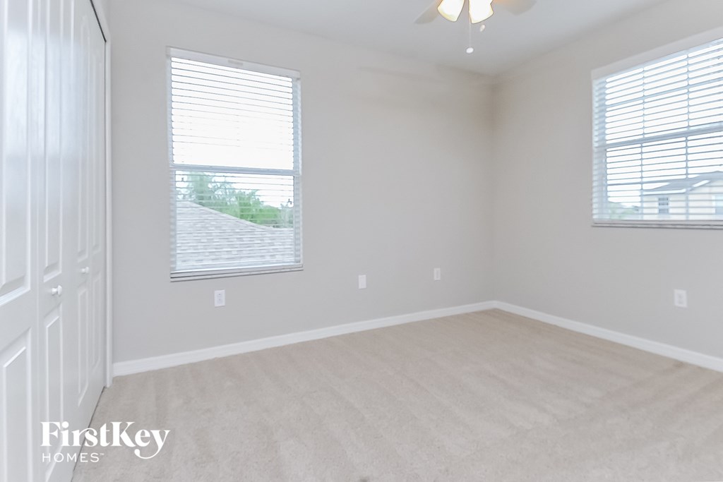 an empty room with two windows and a door