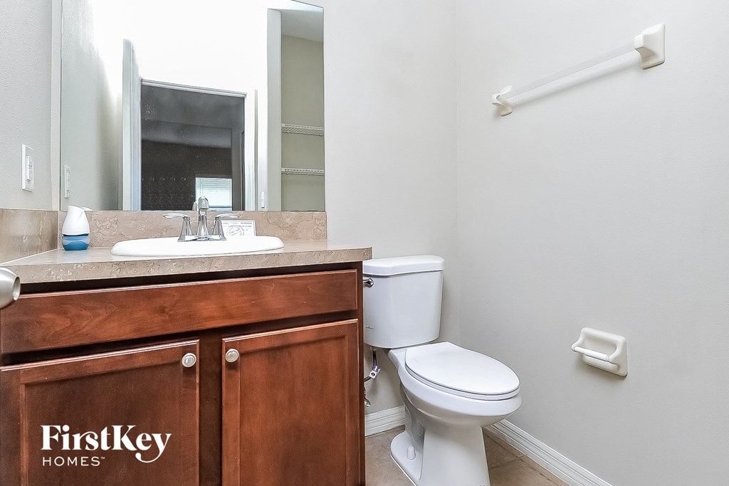 a bathroom with a toilet and a sink and a mirror