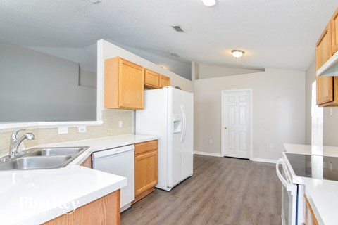 a kitchen with white appliances and wooden cabinets and a white refrigerator