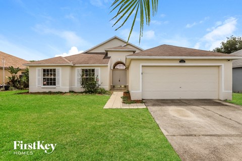 a white house with a lawn and a driveway