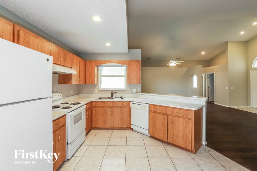 a kitchen with white appliances and wooden cabinets