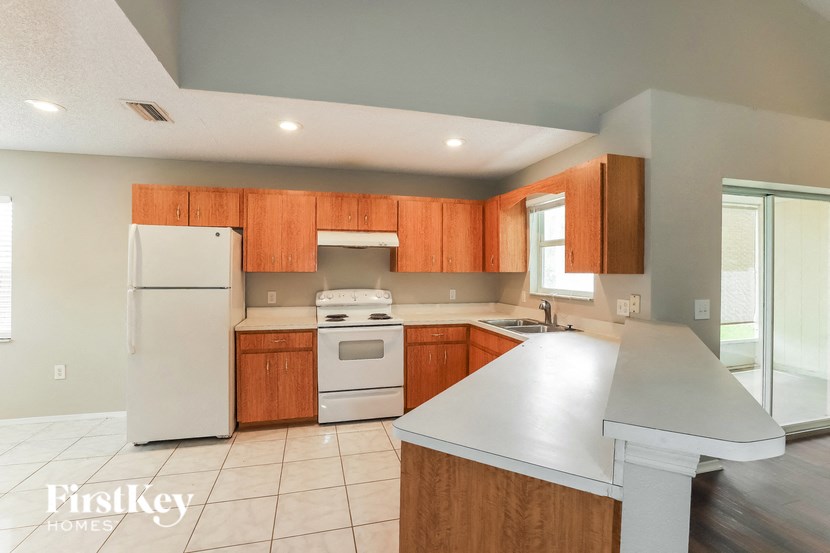 a kitchen with white appliances and wooden cabinets