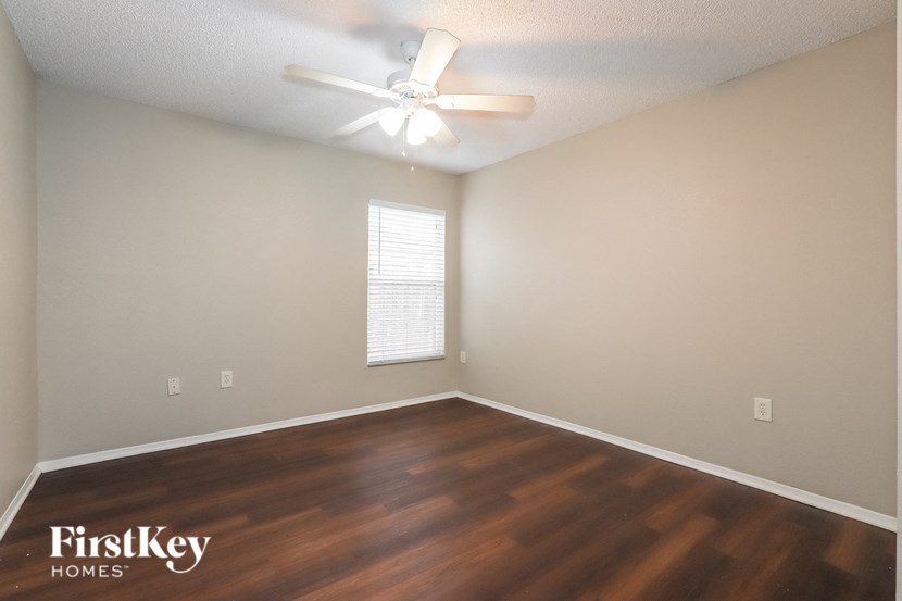 a living room with a ceiling fan and wood floors