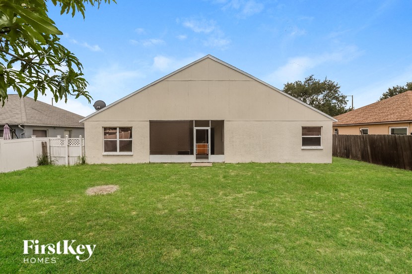 a white house with a grass yard and a fence
