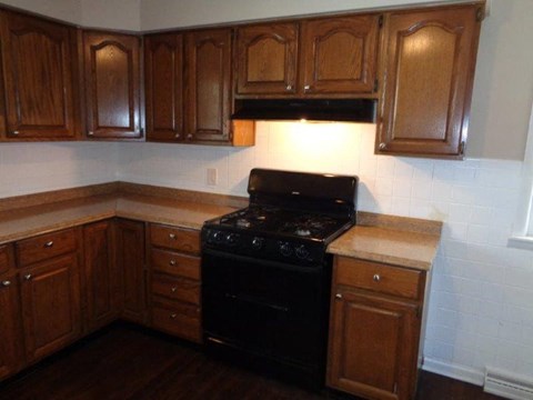 a kitchen with a black stove and wooden cabinets