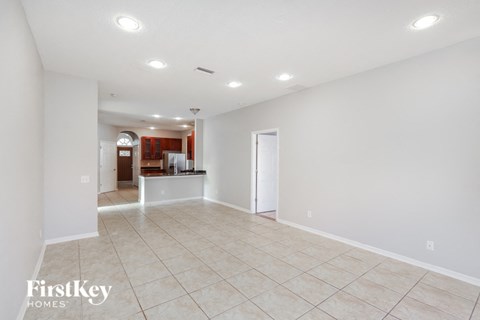 A spacious empty room with tiled flooring and white walls.