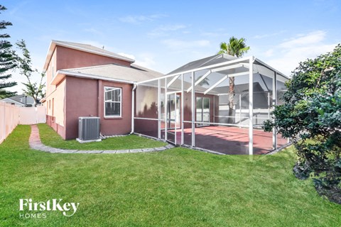 A house with a pink exterior and a white roof is shown with a FirstKey Homes logo.