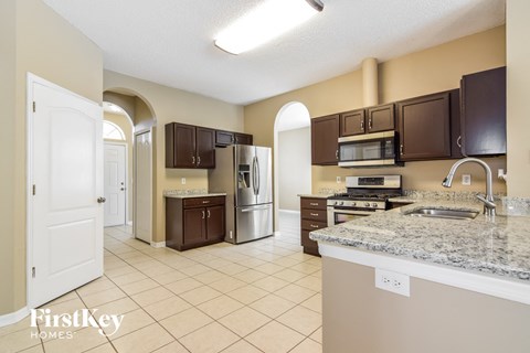 A kitchen with a granite counter top and a sink.