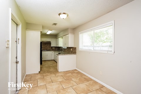 A kitchen area with a tile floor and a window.