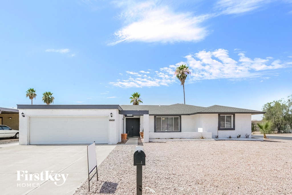 a white house with palm trees and a blue sky