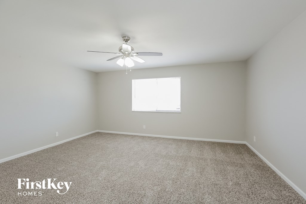 a empty room with a ceiling fan and a window