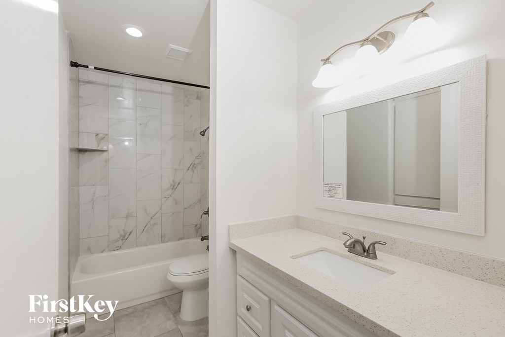 a bathroom with a sink and a shower and a toilet