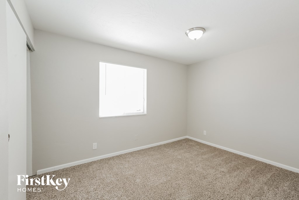 a spacious room with carpet and a window