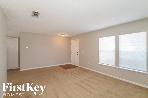 the spacious living room with wood flooring and large windows