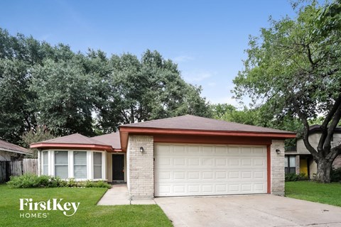 a small brick house with a white garage door
