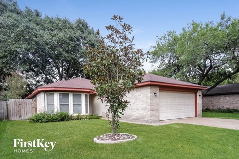 a house with a yard and a tree in front of it