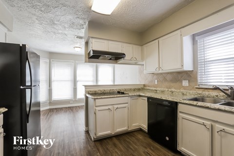 a kitchen with white cabinets and black appliances