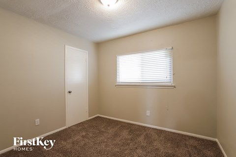 the interior of a bedroom with carpet and a window