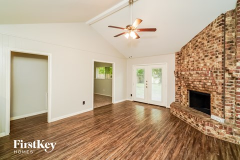 a living room with a fireplace and a ceiling fan