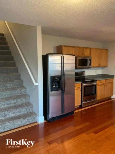 a kitchen with a stainless steel refrigerator next to a staircase