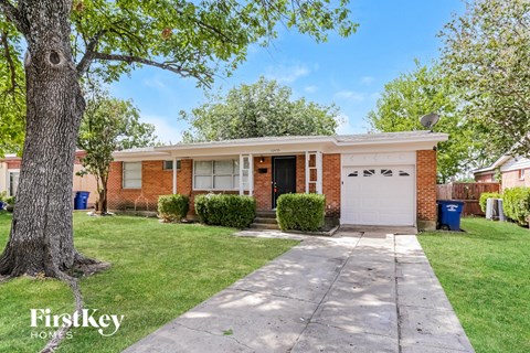a small brick house with a white garage door