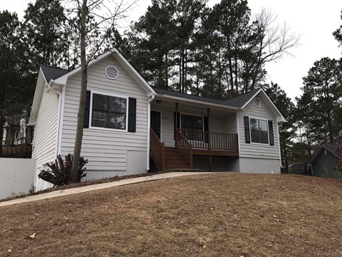 A house with a white siding and a brown roof.
